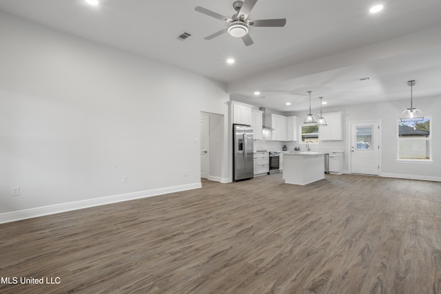 unfurnished living room featuring wood-type flooring, sink, and ceiling fan