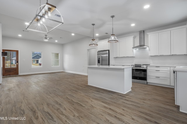 kitchen with wall chimney exhaust hood, stainless steel appliances, a kitchen island, and white cabinets