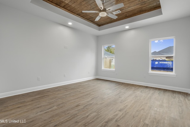 unfurnished room featuring wood ceiling, ceiling fan, a raised ceiling, and hardwood / wood-style flooring