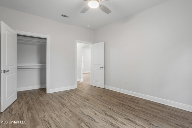 unfurnished bedroom with ceiling fan, hardwood / wood-style floors, and a closet