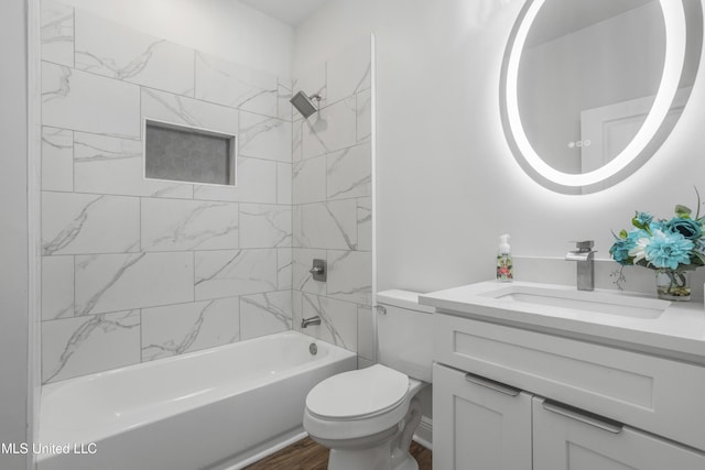 full bathroom featuring tiled shower / bath combo, vanity, wood-type flooring, and toilet