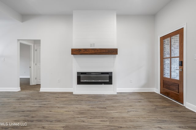 unfurnished living room featuring a fireplace, dark hardwood / wood-style flooring, and heating unit