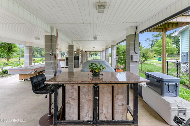 view of patio / terrace with outdoor wet bar and fence