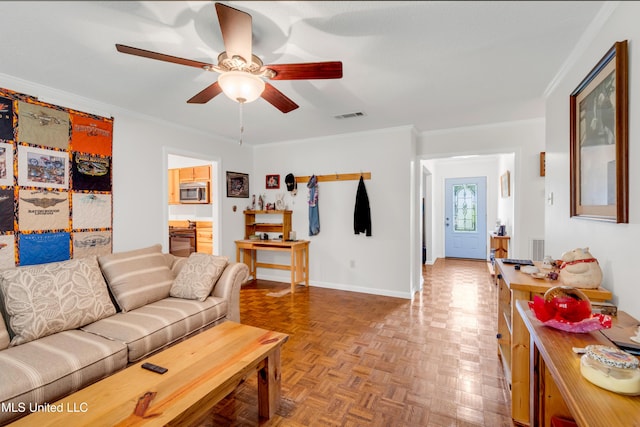 living area featuring a ceiling fan, ornamental molding, visible vents, and baseboards