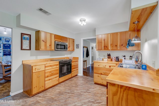 kitchen with wooden counters, visible vents, a sink, stainless steel microwave, and black electric range