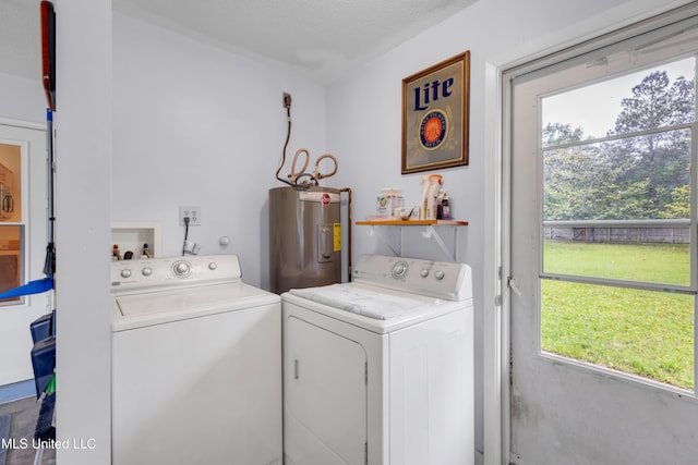 washroom with washing machine and dryer, electric water heater, and laundry area