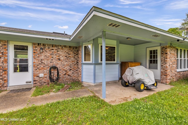 exterior space with a patio area and brick siding