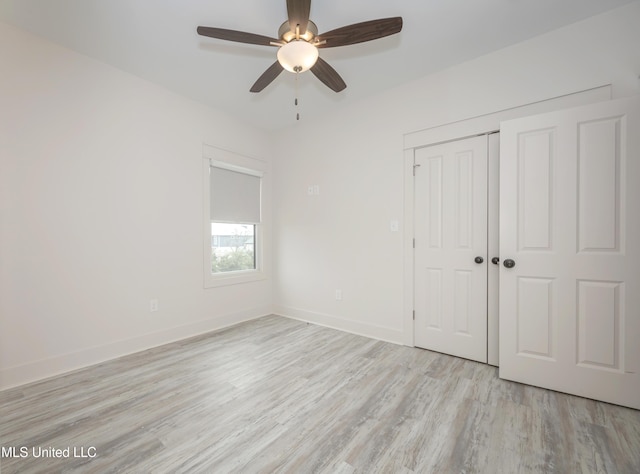 unfurnished bedroom with light wood finished floors, ceiling fan, baseboards, and a closet