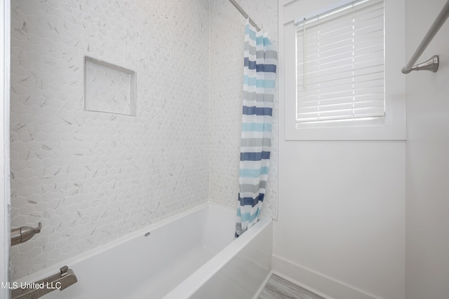 bathroom with hardwood / wood-style flooring and shower / tub combo with curtain