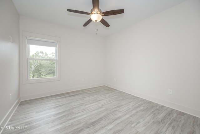 unfurnished room featuring ceiling fan, light wood-style flooring, and baseboards