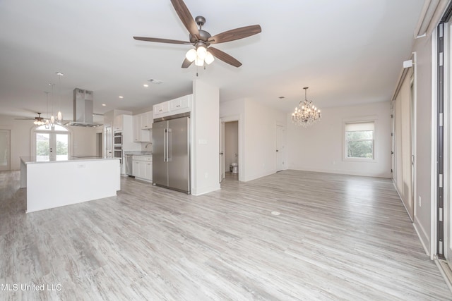 unfurnished living room featuring light wood-type flooring, baseboards, a sink, and ceiling fan with notable chandelier