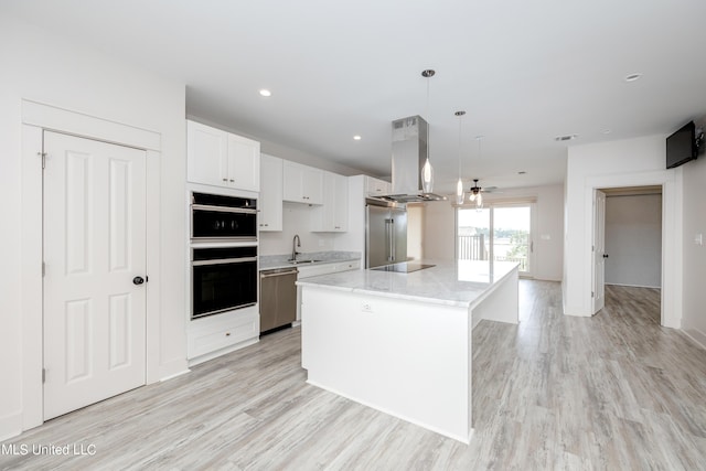 kitchen featuring island range hood, white cabinets, a center island, black appliances, and a sink