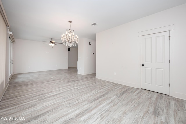 spare room featuring ceiling fan with notable chandelier and light hardwood / wood-style floors