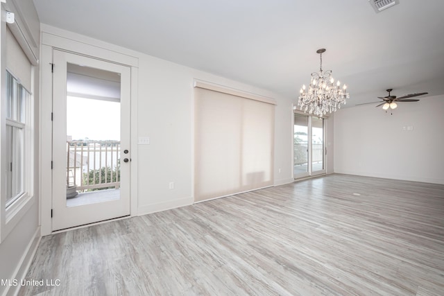 interior space featuring light wood-style floors, baseboards, visible vents, and ceiling fan with notable chandelier