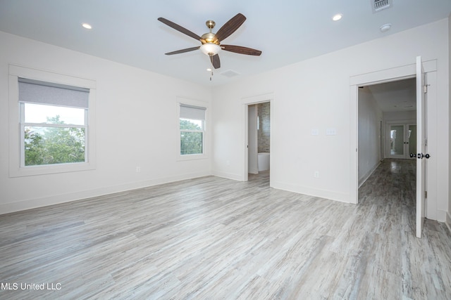 empty room with ceiling fan, light hardwood / wood-style floors, and a healthy amount of sunlight