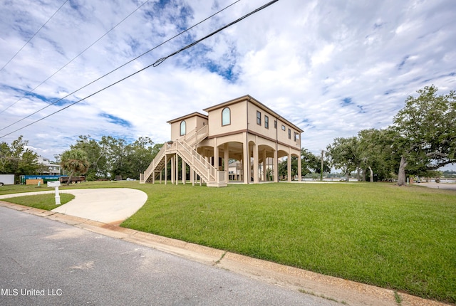 view of front of property featuring stairway and a front yard