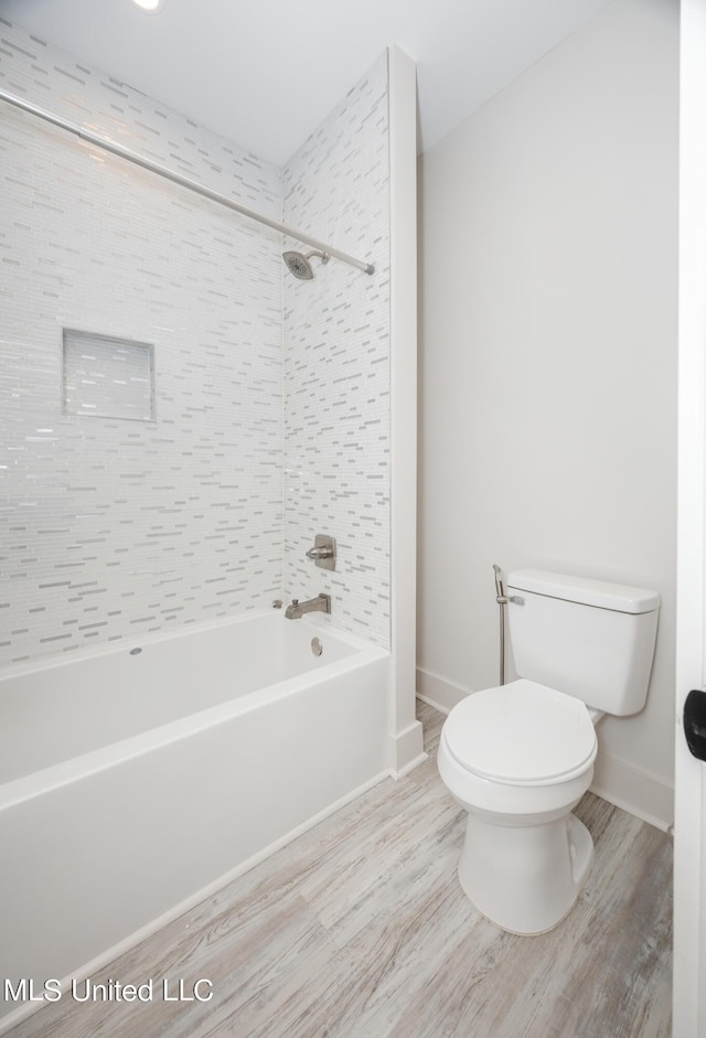 bathroom with  shower combination, wood finished floors, toilet, and baseboards