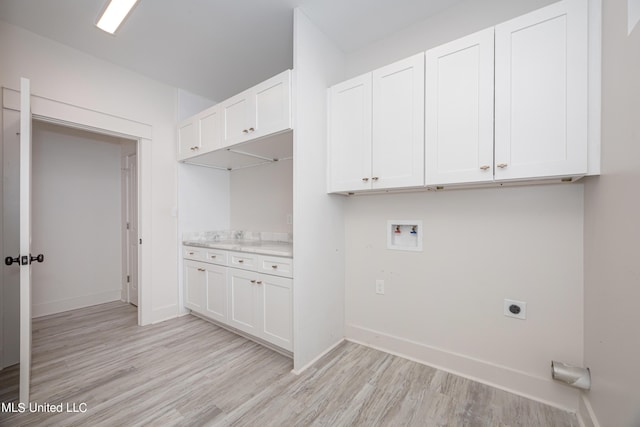 washroom with hookup for an electric dryer, cabinets, light wood-type flooring, and washer hookup