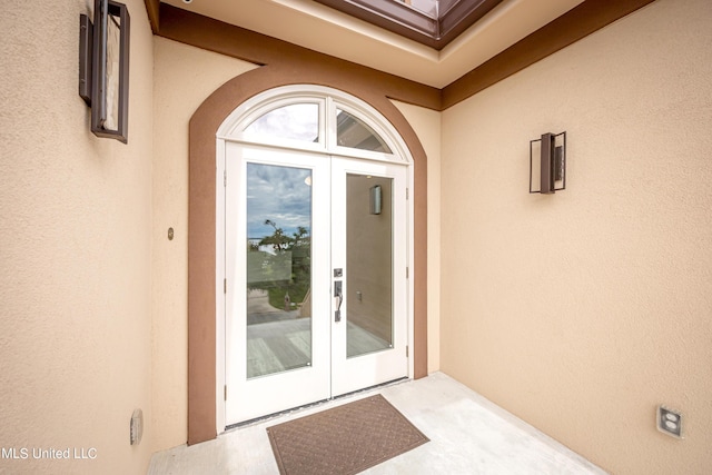 property entrance featuring french doors and stucco siding