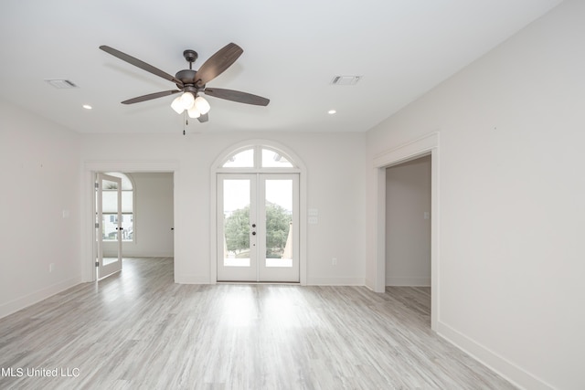 empty room with french doors, light hardwood / wood-style floors, and ceiling fan