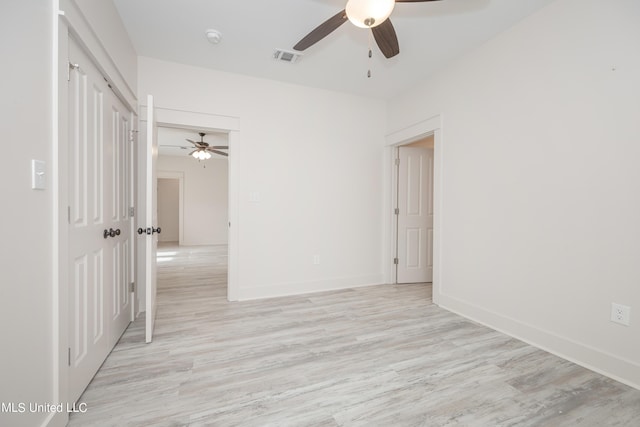 empty room featuring light wood-type flooring, ceiling fan, and baseboards