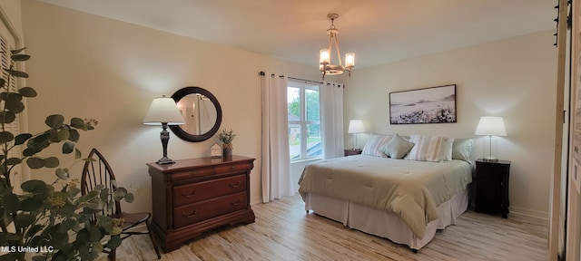 417 Highpoint Dr, Diamondhead, MS 39525 - bedroom with light wood-style floors, a chandelier, and baseboards