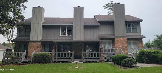 417 Highpoint Dr, Diamondhead, MS 39525 - view of front of property featuring a porch, a front yard, brick siding, and board and batten siding