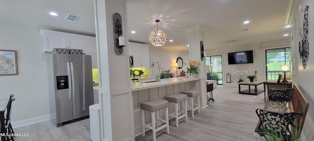 417 Highpoint Dr, Diamondhead, MS 39525 - kitchen with appliances with stainless steel finishes, light countertops, white cabinetry, a breakfast bar area, and open floor plan