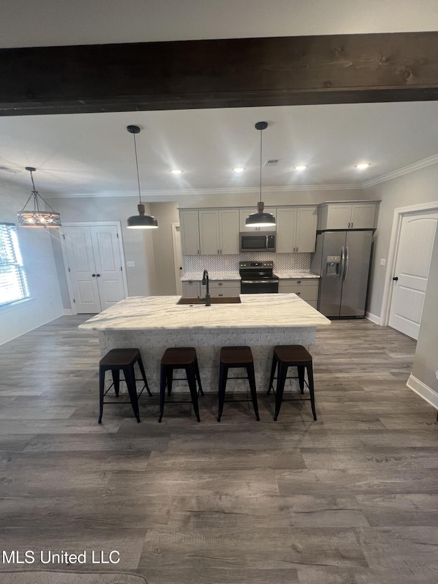 11368 Cedar Point Cv, Hernando, MS 38632 - kitchen featuring appliances with stainless steel finishes, a kitchen breakfast bar, baseboards, a large island with sink, and crown molding