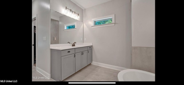 11368 Cedar Point Cv, Hernando, MS 38632 - bathroom featuring vanity, baseboards, and a freestanding tub