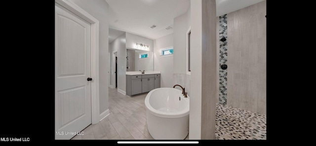 11368 Cedar Point Cv, Hernando, MS 38632 - full bath featuring a freestanding tub, a tile shower, vanity, and baseboards