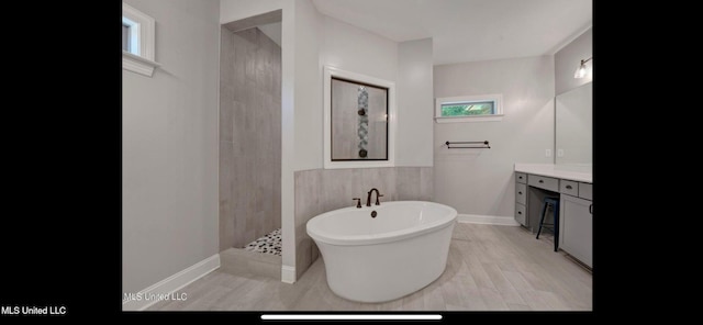 11368 Cedar Point Cv, Hernando, MS 38632 - bathroom with a freestanding tub, vanity, walk in shower, baseboards, and wood finished floors