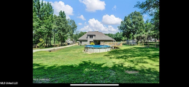 11368 Cedar Point Cv, Hernando, MS 38632 - view of green lawn with a trampoline and an outdoor pool