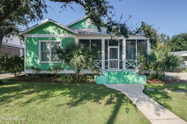 bungalow-style house featuring a front lawn and a sunroom