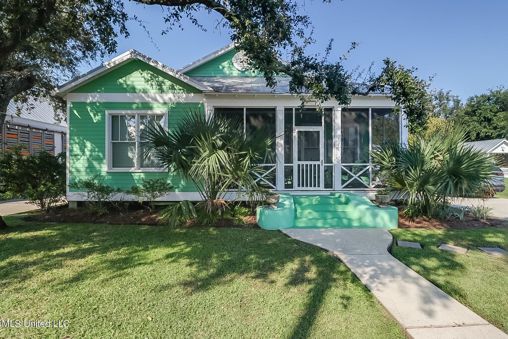 111 Sycamore St, Bay Saint Louis, MS 39520 - view of front of property featuring a front lawn and a sunroom