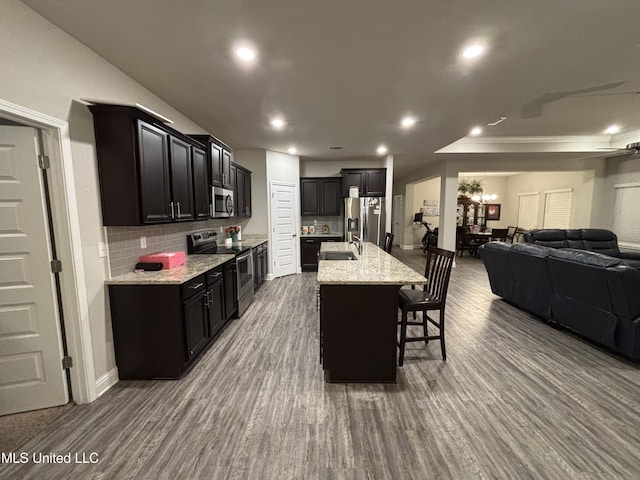 10645 Chapelwood Dr, Gulfport, MS 39503 - kitchen featuring dark wood finished floors, a sink, appliances with stainless steel finishes, a kitchen bar, and open floor plan