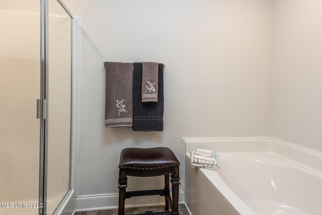 bathroom featuring shower with separate bathtub