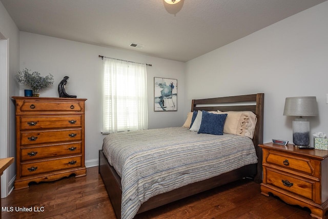 bedroom with dark hardwood / wood-style flooring