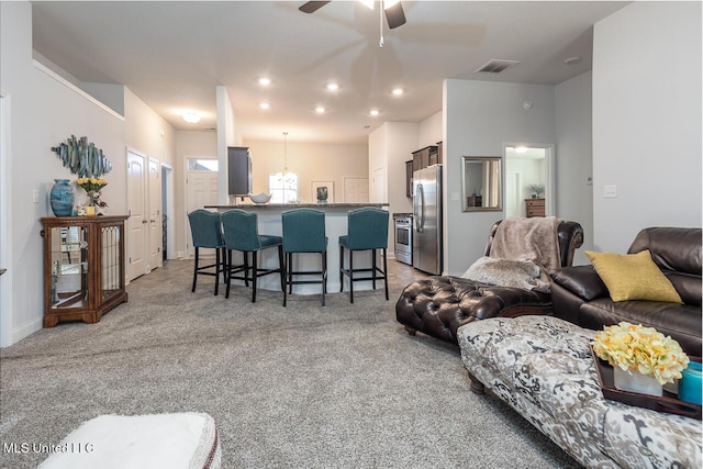 carpeted living room with ceiling fan