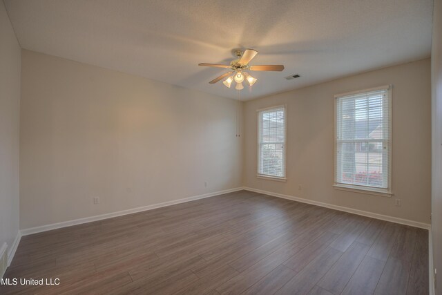 empty room with hardwood / wood-style flooring and ceiling fan