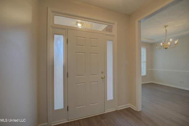 entryway featuring wood-type flooring and an inviting chandelier