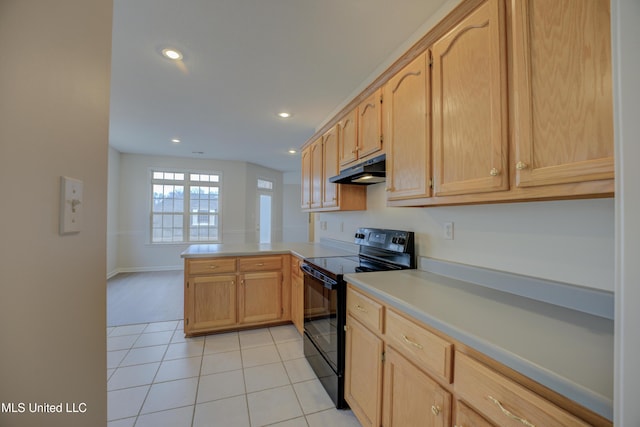 kitchen with light tile patterned flooring, kitchen peninsula, black range with electric cooktop, and light brown cabinets