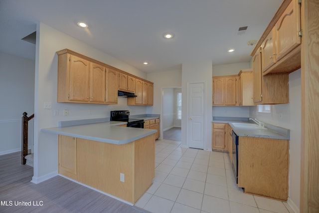 kitchen with light tile patterned flooring, black appliances, sink, kitchen peninsula, and light brown cabinets