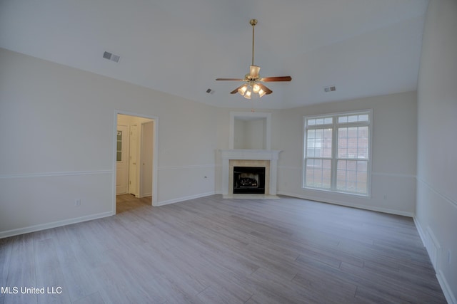 unfurnished living room featuring a tile fireplace, ceiling fan, and light wood-type flooring