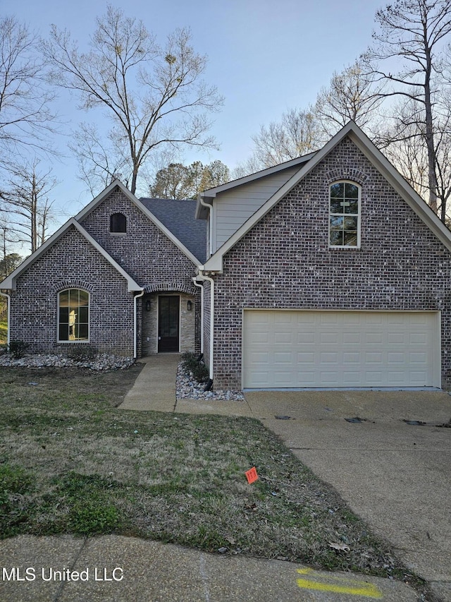 traditional home with brick siding, a shingled roof, a front lawn, concrete driveway, and a garage