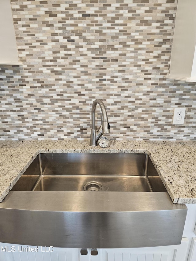 interior details with backsplash and a sink