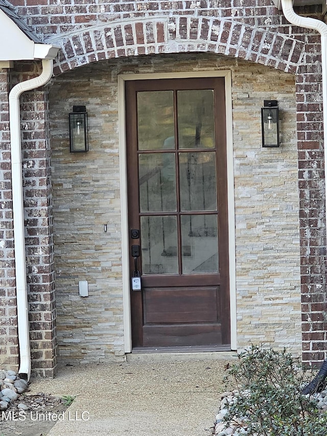 view of exterior entry featuring brick siding