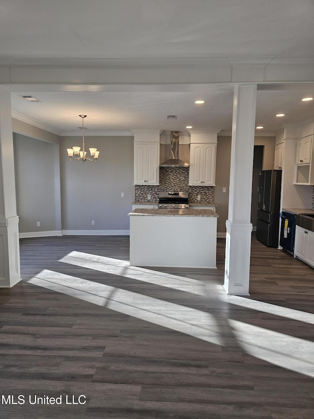 kitchen with white cabinetry, wall chimney exhaust hood, ornamental molding, and freestanding refrigerator