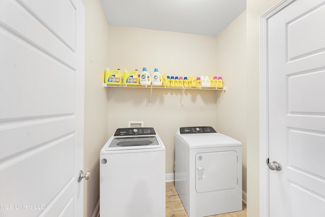 washroom with laundry area, light wood finished floors, and independent washer and dryer