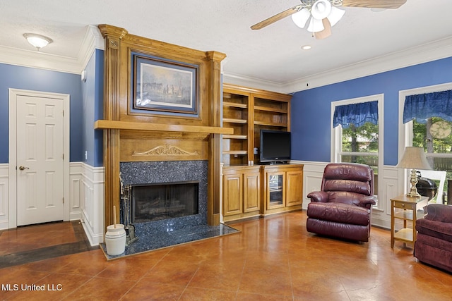 114 Sandstone Dr, Brandon, MS 39047 - tiled living room with ceiling fan, crown molding, a fireplace, wainscoting, and a decorative wall